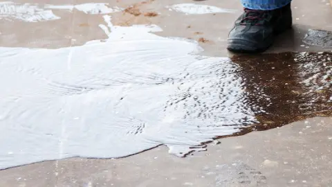 Water spreading across a floor from a leak